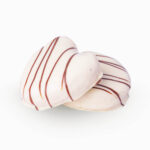 mini Palmera sabor Kinder es un Hojaldre con forma de palmera con crema de avellana cubierto de cobertura blanca y decorado con cobertura negra